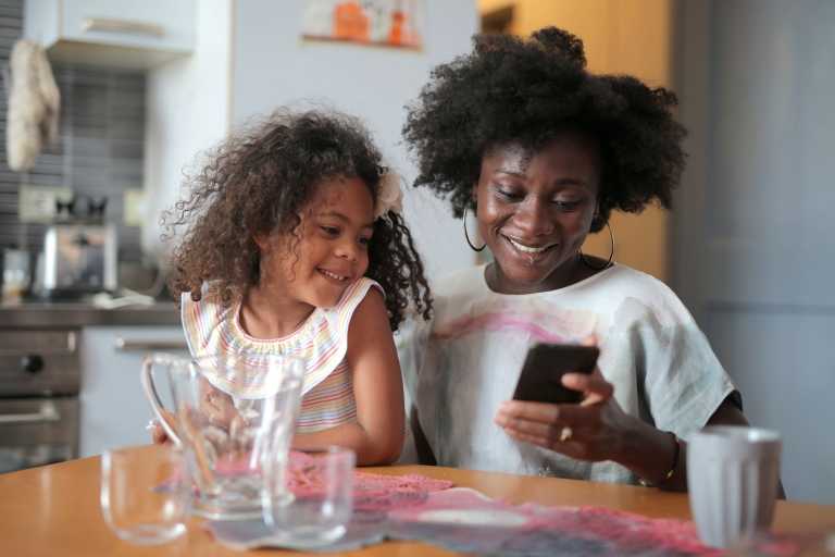 woman and her daughter looking at phone