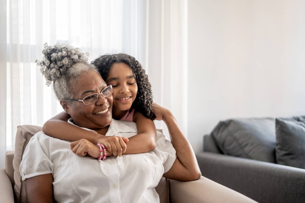 Portrait of grandmother and granddaughter hugging