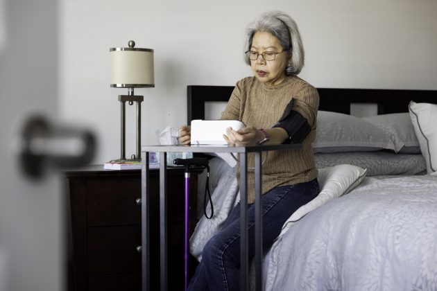 High quality stock photos of an  Asian American Filipino senior woman engaged in home healthcare screening and monitoring.